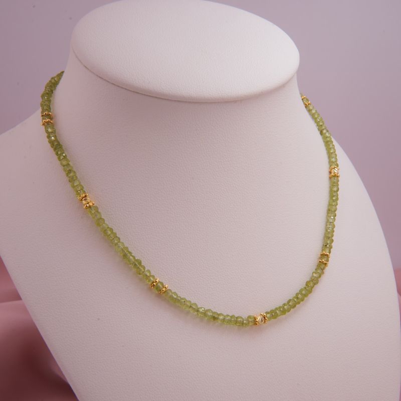 Preview: Filigrane, grüne Peridot-Kette auf einer Schmuckbüste präsentiert, um den perfekten Fall und die Länge am Dekolleté zu zeigen.